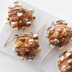 four desserts with marshmallows and chocolate drizzled on them