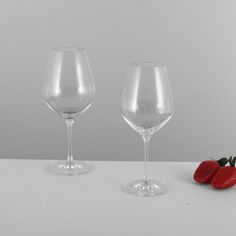 two wine glasses with strawberries on the table