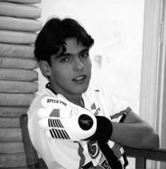 a young boy sitting at a table with gloves on his hands and looking off to the side