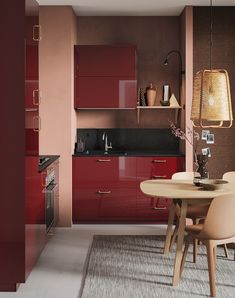 a kitchen with red cabinets and an area rug on the floor that has a table in front of it