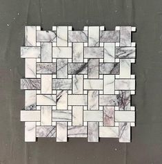 a white and grey tile pattern on the wall in an area that looks like it has been made out of marble