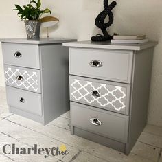 two grey dressers with white and silver drawers on each side, one has a plant in the middle