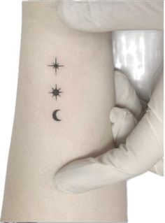 a woman's stomach with three stars and a crescent tattoo on her left side