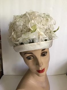 "Vintage 1960's hat. White floral with Green leaves bucket style hat. The label is *SEARS Fashion Millinery*. Sears Roebuck and Co. USA. *MORE INFORMATION BELOW* CONDITION: No issues noted. MEASURES: Inside circumference~21 1/2\" Height~5\" Front to back~8\" Left to right~7\" *WE APOLOGIZE~BUT WE NO LONGER SHIP TO GERMANY, ITALY OR SPAIN. IF ORDERS COME IN FROM GERMANY, ITALY OR SPAIN, WE WILL HAVE TO CANCEL THEM AND REFUND YOUR MONEY. SORRY FOR THIS INCONVENIENCE*" White Retro Bucket Hat With Curved Brim, White Vintage Cloche Fascinator, Vintage White Cloche Fascinator, Retro Wide Brim White Hat, Retro White Wide Brim Hat, White Wide Brim Retro Hat, Vintage Curved Brim Top Hat For Royal Ascot, Vintage White Brimmed Hat, Vintage White Fascinator Hat