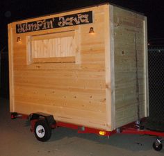 a small wooden trailer with a sign on the side