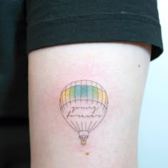 a hot air balloon tattoo on the left thigh