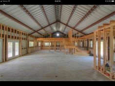 the inside of a building with wood framing on the walls and stairs to the second floor