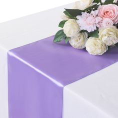 a purple table runner with white and pink flowers