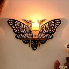 a wall mounted candle holder with a butterfly on it