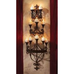 a wall mounted candle holder with many lit candles