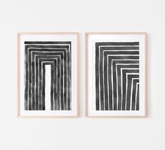 two black and white paintings hanging on the wall