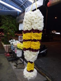 a bunch of flowers that are hanging from a pole