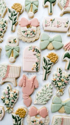 some decorated cookies are laying on a white counter top with pink and green decorations around them