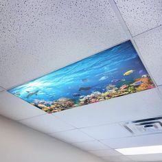 the ceiling in an office is decorated with colorful fish and corals, as well as a flat screen tv