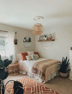 a bed room with a neatly made bed next to a window and potted plants