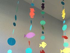 colorful paper fish and seahorses hanging from the ceiling in a child's room