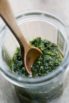 a wooden spoon in a jar filled with pesto