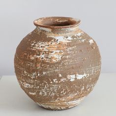 a brown vase sitting on top of a white table