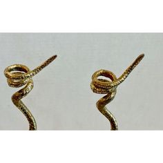 two gold colored rings with twisted ends on each end, one in the shape of a snake