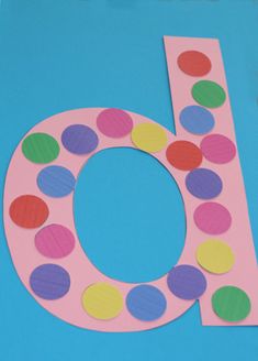 the letter b is made out of paper with polka dots on it and sits in front of a blue background