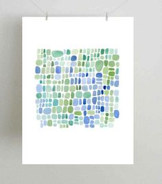 a white poster hanging on a wall with blue and green circles in the middle,