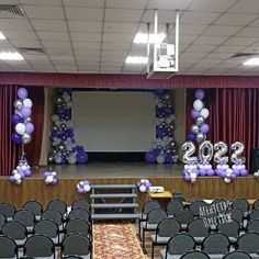 an empty auditorium with chairs and balloons on the stage for a new year's eve celebration