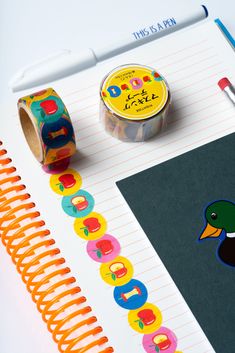 an assortment of stationery items on top of a notepad with a rubber duck