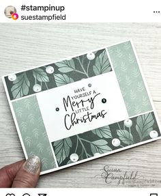 someone is holding up a christmas card with the words merry and leaves in black on it