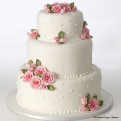 a three layer white cake with pink flowers on it