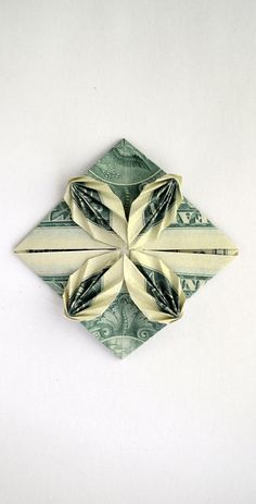 an origami flower made out of one dollar bill on a white table top