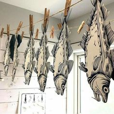 some fish are hanging from clothes pins on a line