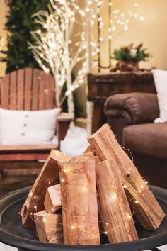 a pile of wood sitting on top of a black plate next to a christmas tree