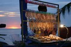 the food is being prepared for consumption on the boat by the water at sunset or dawn