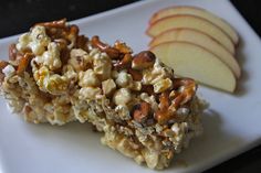 a white plate topped with granola and an apple