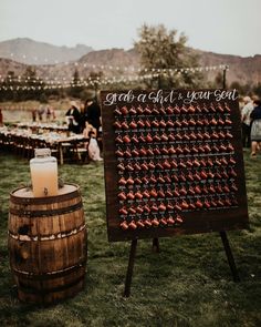 a wooden barrel with a sign that says grab a seat, your seat and some drinks on it