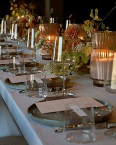 a long table is set with candles and place settings