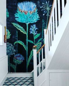 an instagram photo with flowers painted on the wall next to stairs and railings