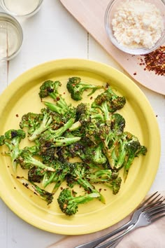 a yellow plate topped with broccoli next to other dishes