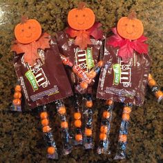 four candy sticks with candies in the shape of pumpkins and leaves on them