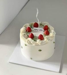 a cake with white frosting and strawberries on top