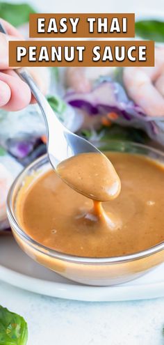 a spoon full of peanut sauce on top of a white plate with lettuce