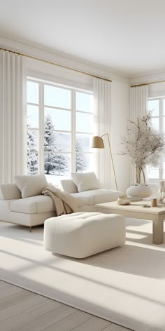 a living room with white furniture and large windows