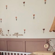 a baby's room with wall decals and a crib