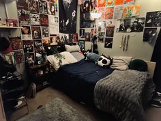 a bed room with a neatly made bed and lots of posters on the wall