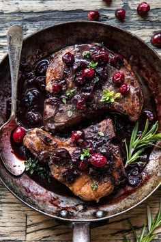 pork chops with cranberry sauce in a cast iron skillet on a wooden table