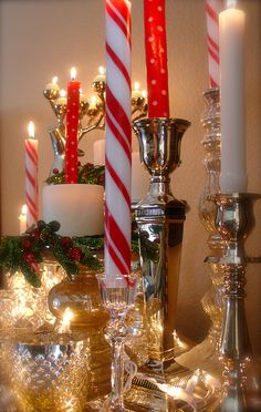 three candles are lit on a table with other christmas decorations