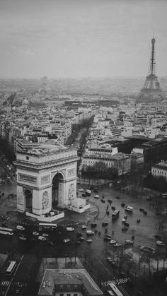 black and white photograph of the eiffel tower in paris, with cars parked below it