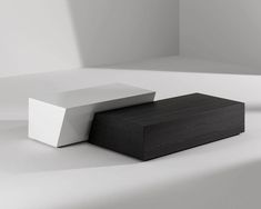 two black and white boxes sitting on top of each other in the middle of a room