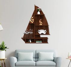 a living room with a blue couch and wooden shelves on the wall, filled with wine glasses