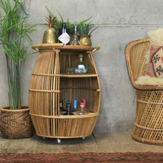 two wicker chairs and a bamboo shelf with bottles on it next to a wall